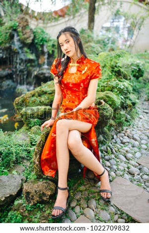 Portrait of beautiful asian woman in red chinese dress traditional cheongsam. photographs vintage film style.
