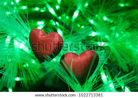 Two Valentine Heart among lights on pine tree