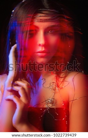 Portrait of a girl, model shot on a long exposure in the studio with color filters. Portrait, fashion, beauty, glow.