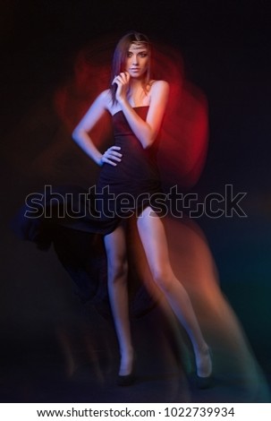 Girl, model photographed on a long exposure in the studio with color filters. Portrait, fashion, beauty, glow.