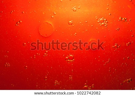 Oil and water are two liquids that will not mix together. red background