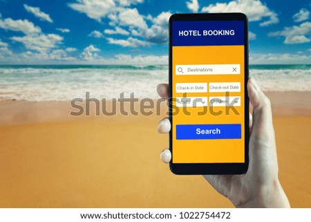 Hand holding smartphone with hotel booking application on the beach and blue sky