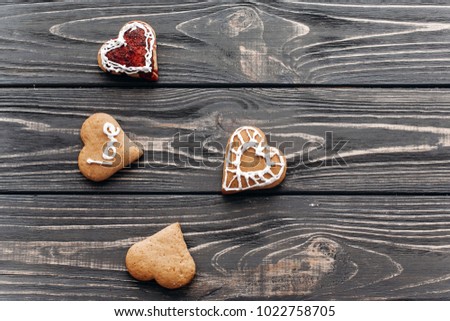 Delicious dessert for wedding, romantic food - heart shaped cookies with love text and tasty frosting close-up on wood background, hipster sweets for Valentines day with space for text
