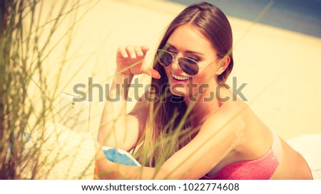 Fun and joy. Summer time. Young beauty girl spending time on beach taking selfie photo by mobile phone. Positive woman with smartphone lying on blanket.