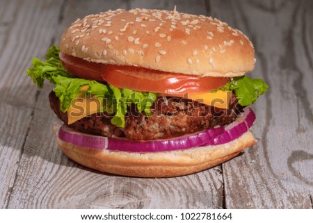 Cheeseburger on rusticwooden table. 