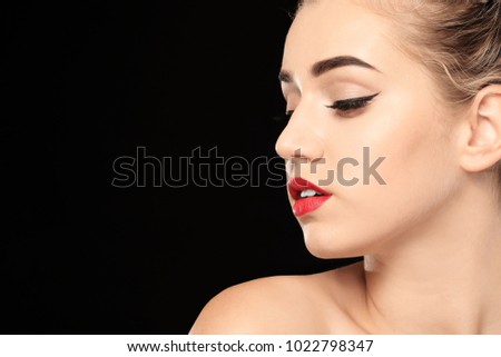 Portrait of young woman with beautiful eyebrows on dark background, closeup