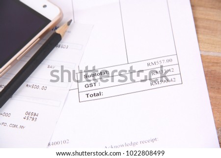Photo for payment bill,coins, mobile and bank slip on the wooden table. close up image. 