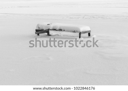 single bench covered with snow, winter day, black and white picture