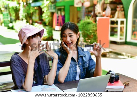 Relaxation concept. A tourist girl searching for accommodation on the internet and map. Asian women are shopping on the internet. Beautiful young women are happy to use a credit card.