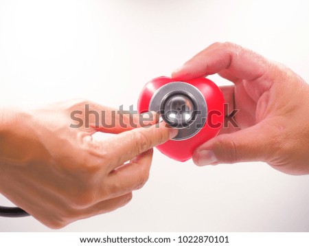 hand holding red heart and stethoscope showing heart inspection concept.