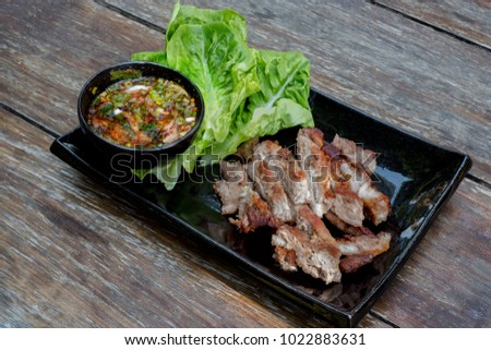 Grilled pork with sauce on wooden floor