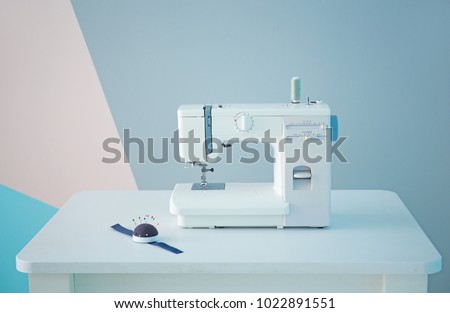 Sewing machine on table in tailor's workshop Royalty-Free Stock Photo #1022891551