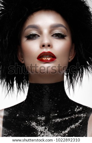 Beautiful fashion woman with creative make-up and black wig. The beauty of the face. Photos shot in the studio.