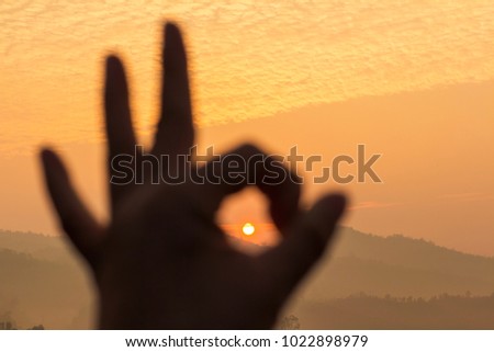Silhouette hands shape sign and sunrise sky