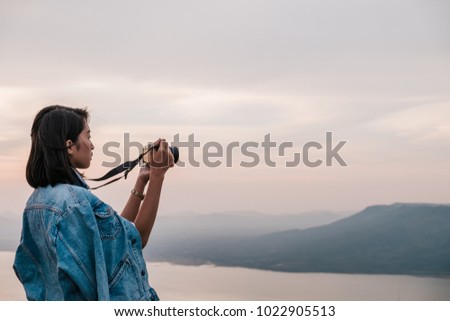 Young woman taking photos in a park