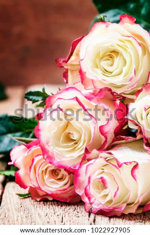 Festive bouquet of red and white roses, Valentines Day card, vintage wooden background, selective focus