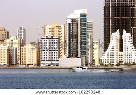 A speedboat speeding against the Bahrain highrise building