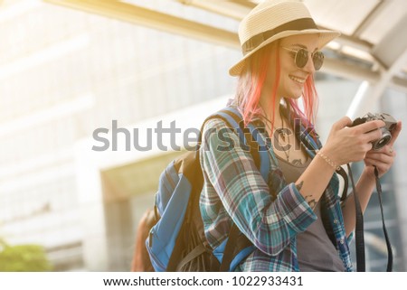 Russian traveller with backpack checking picture taken by her camera