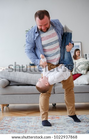 Family picture of father holding son in apartment