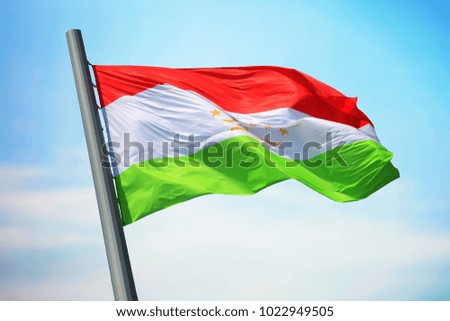 Flag of Tajikistan against the background of the blue sky
