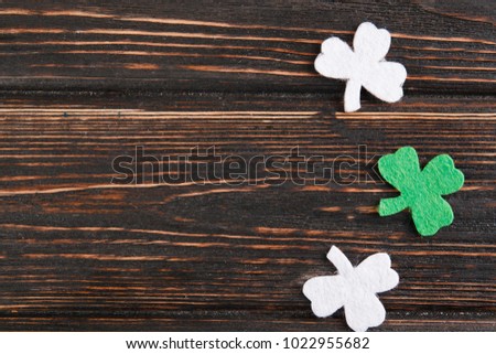 St Patricks Day corner border of shamrocks and gold coins over a rustic wood background