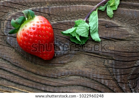 Strawberry with mint leaves on antique wooden table
