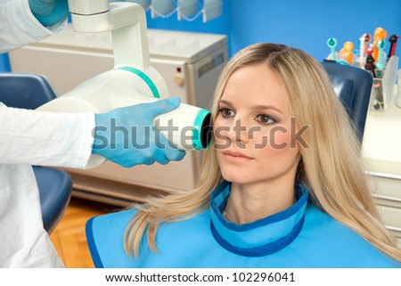 attractive woman patient at dentist taking x-ray exam