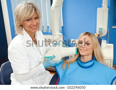dentist using x-ray machine on girl patient