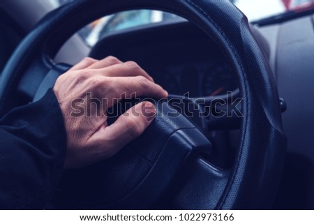 Male hand honking the car horn, man driving vehicle and beeping, ultra violey toned shadows