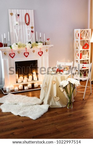 A picture of a nice cozy room decorated for a romantic date on a St. Valentines Day.