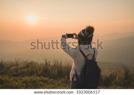 Young traveler taking photo beautiful landscape sunset