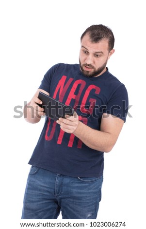 A standing young man playing with the tablet looked surprised, isolated on a white background.