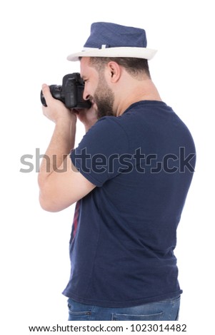 A rear view of a standing photographer taking photos with his camera, isolated on a white background.