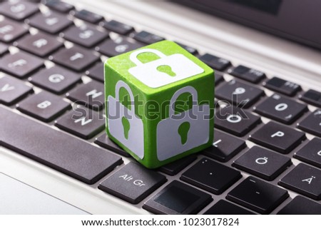 Close-up Of Lock Symbol On Green Wooden Block Over The Laptop Keypad