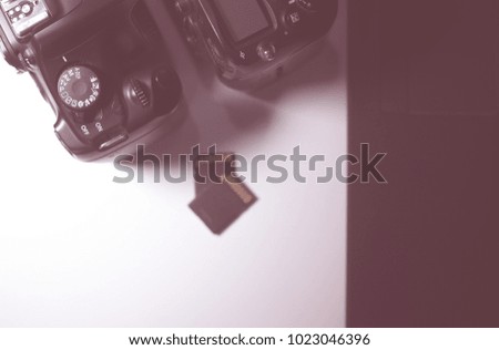 Digital camera with  memory card on table preparing to transfer photos,Vintage toned