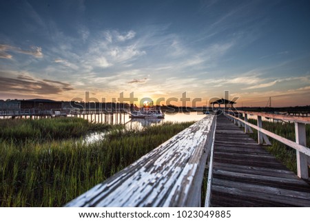 Old wooden dock leading to a beautiful sunrise over the marsh in Savannah, Georgia, USA Royalty-Free Stock Photo #1023049885