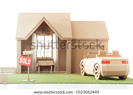 cardboard house and car with sign sold isolated on white