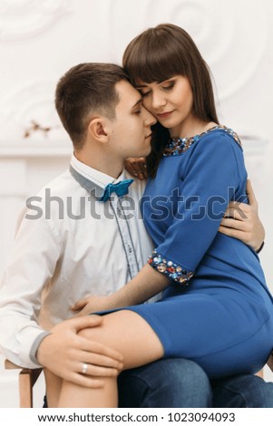 Man holds woman tender on his knees sitting before a fireplace