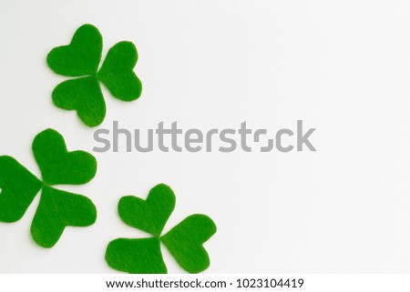 Shamrocks from green felt on the white background. St. Patrick's Day concept. Top view, flat lay, copy space