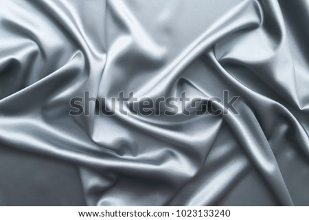 Beautiful smooth elegant dark grey or silver silk or satin luxury cloth fabric texture, abstract background design.