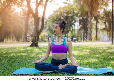 The girl practicing yoga in the park.
