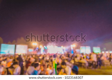 vintage tone blur image of people in night festival with performance stage on street with bokeh for background usage .