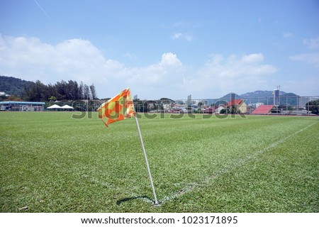 Red and yellow corner flag at the football field with bluesky background