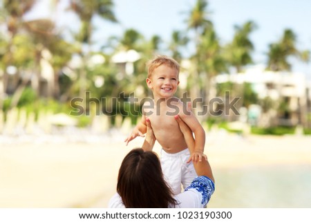 Picture of mother having fun on the beach with her little son