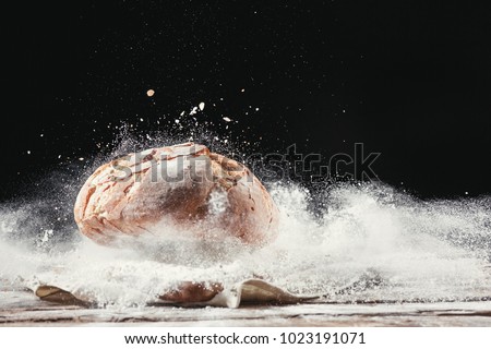 Fresh bread on table close-up in flour placer. Fresh bread on the kitchen table. The healthy eating and traditional bakery concept. Rustic style Royalty-Free Stock Photo #1023191071