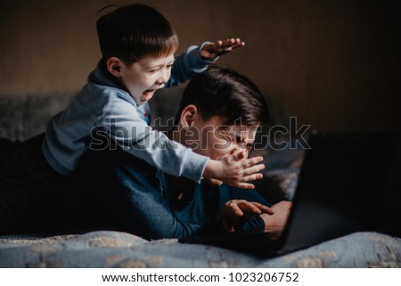 child playing with dad near laptop