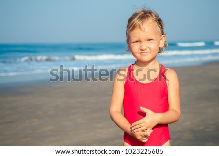charming little girl is sad on the beach