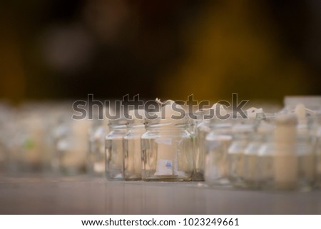 Candles in jars on a holiday with people and children memorial wedding day event