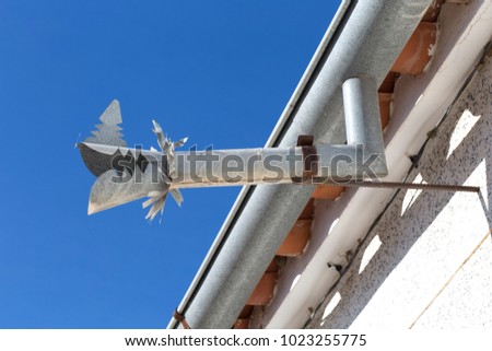 Zinc gutter drainage system dragon shaped over blue sky. Southern spain