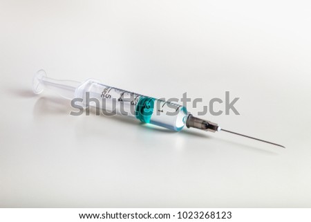 One syringe on white table prepared for injection in hospital Royalty-Free Stock Photo #1023268123